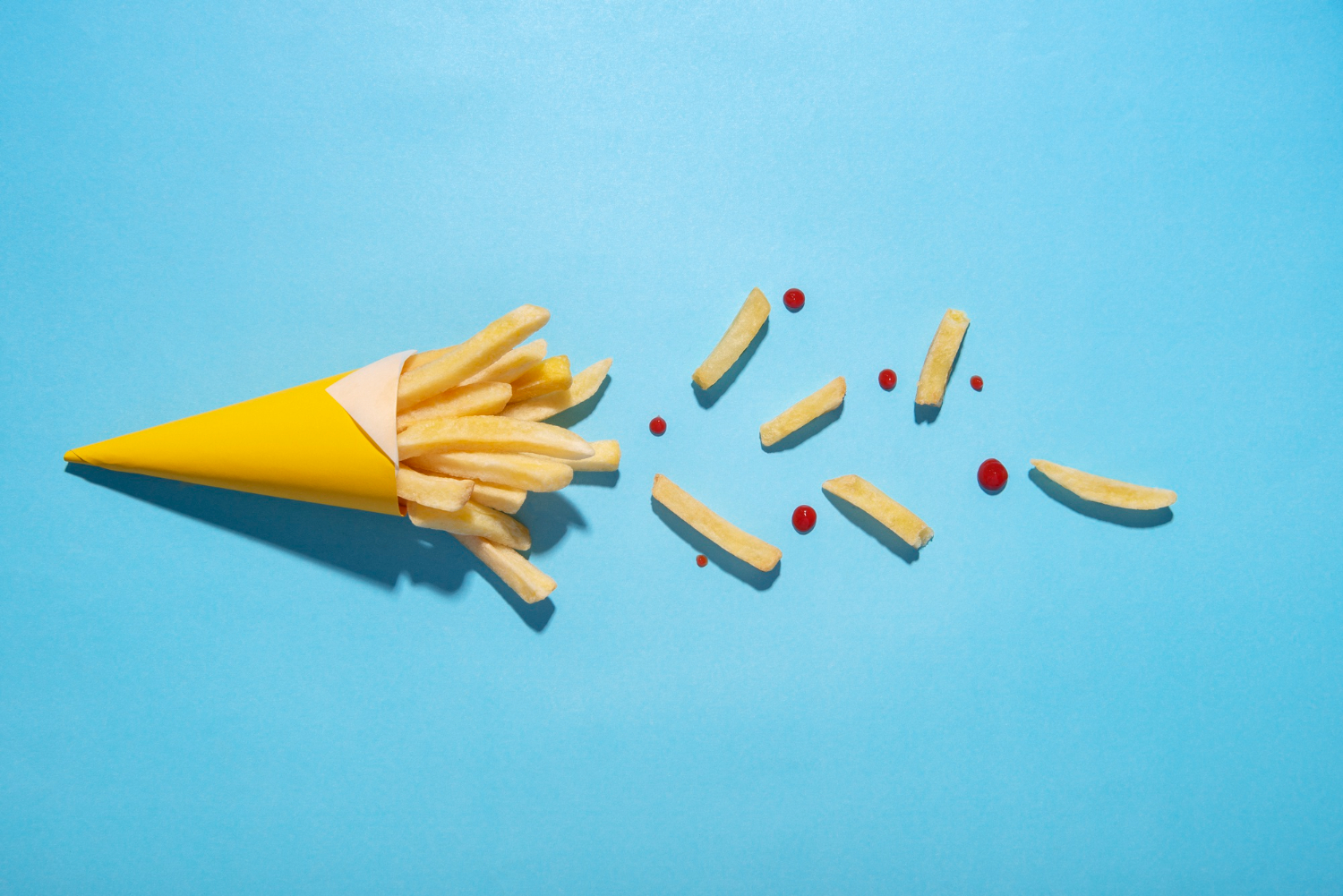 top view of french fries cone on blue surface
